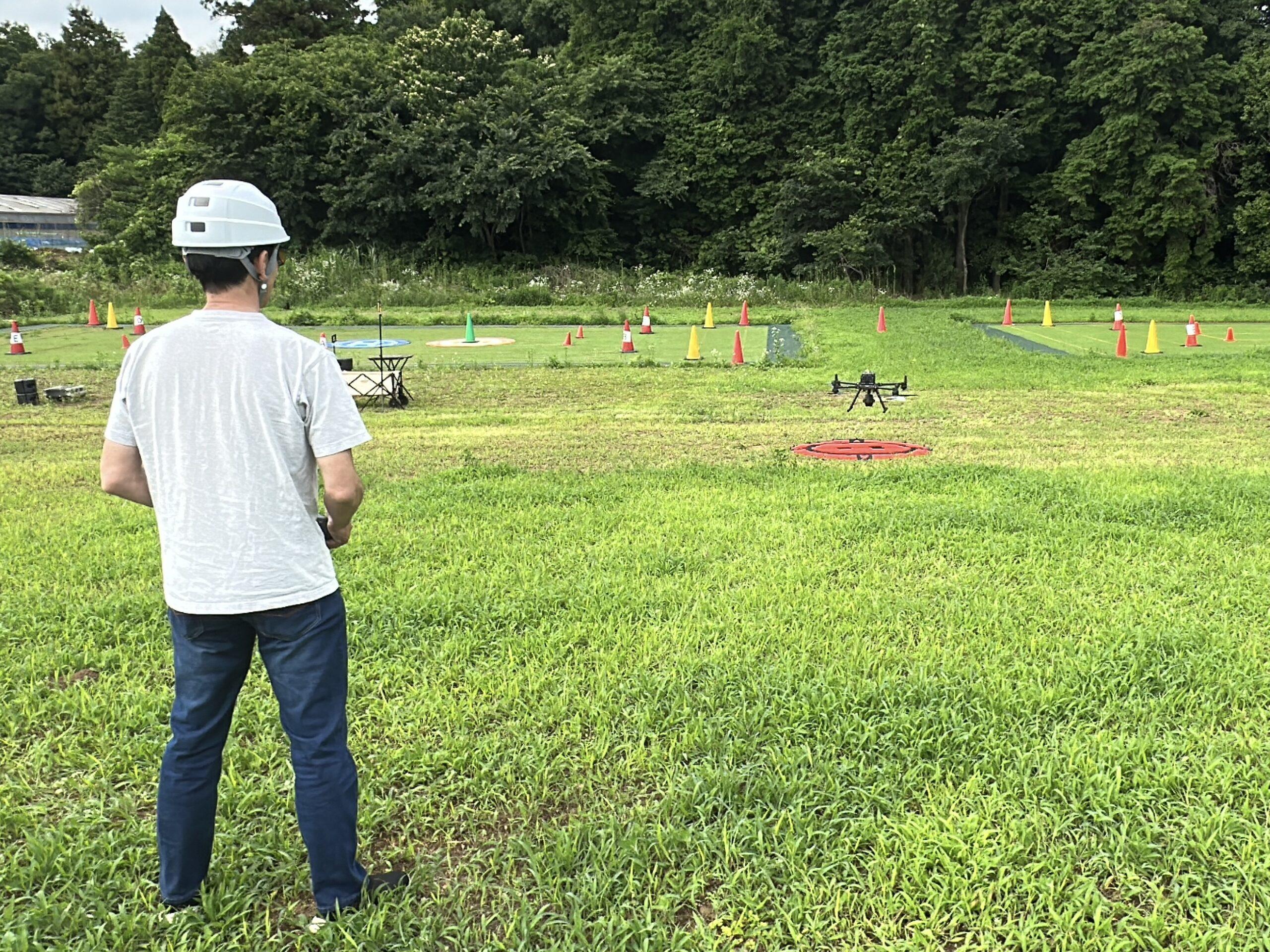 屋外実習場でドローンを操縦する受講者